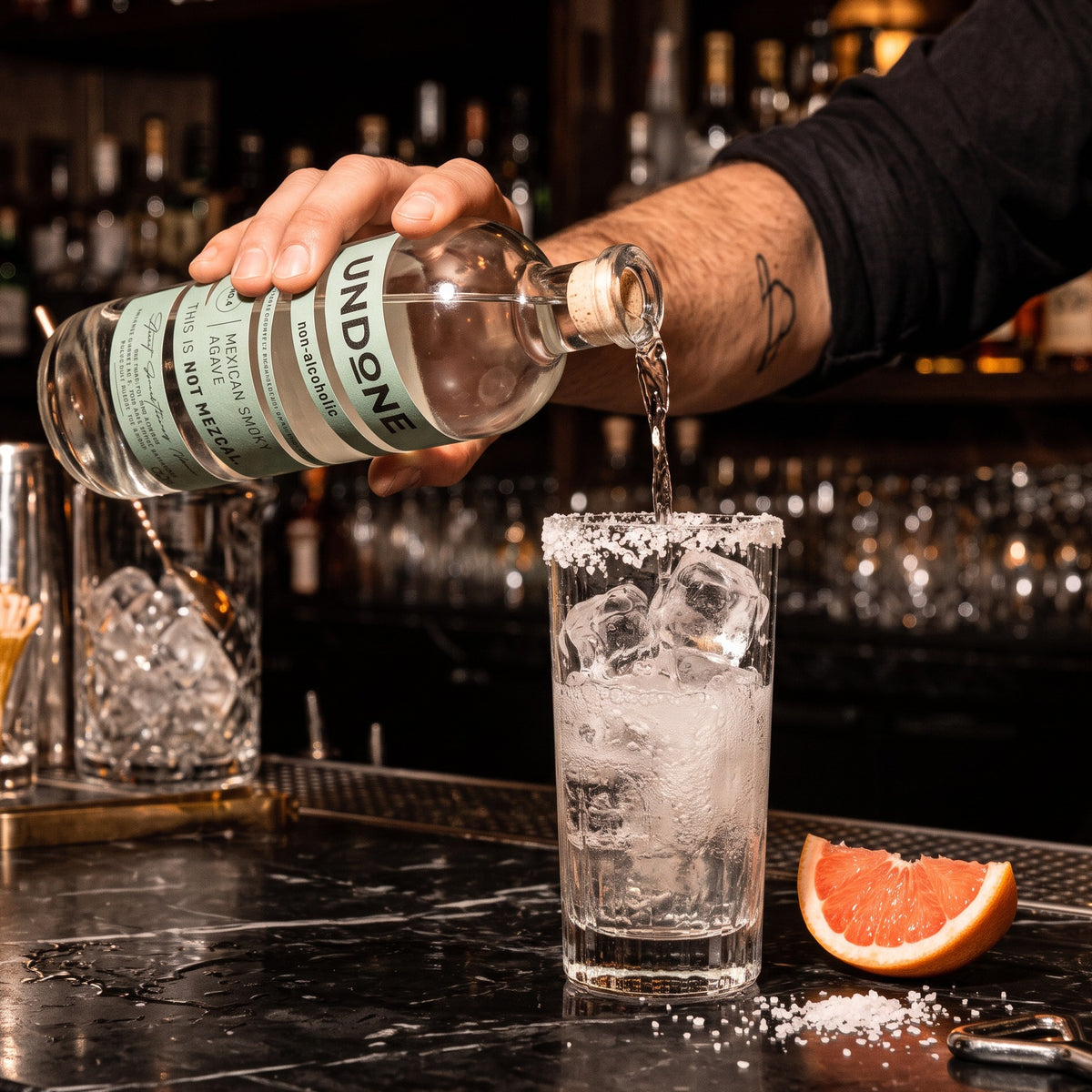 Bartender pouring UNDONE No. 4 NOT MEZCAL into a salt-rimmed highball