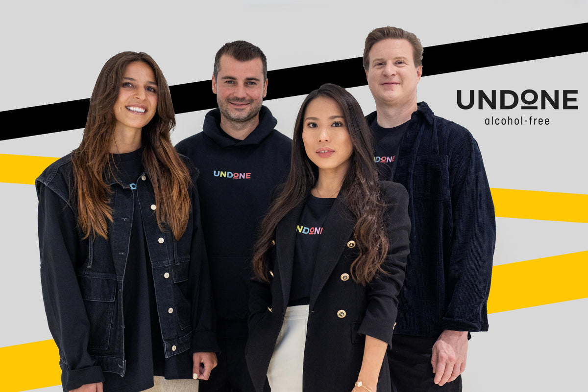 The UNDONE founding team in front of the UNDONE logo